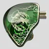 A close-up studio shot of a green in-ear headphone with a gold phoenix design. Náhľad obrázku produktu
