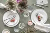 A beautifully set table with plates, cutlery, glasses, and floral arrangements. Podgląd zdjęcia produktu