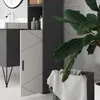 A bathroom scene with a tall cabinet, a sink, and a plant. Produktbild-Vorschau