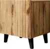 A close-up side view of a wooden nightstand with black legs. Náhled obrázku produktu