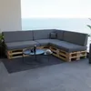 A sectional sofa made of wooden pallets with gray cushions is placed on a balcony overlooking the ocean. Produktbild-Vorschau