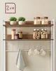 A kitchen rack with various items displayed on its shelves, including plants, jars, and mugs. Náhled obrázku produktu