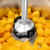 A close-up shot of an immersion blender head surrounded by chopped mangoes in a metal bowl. Produktbild-Vorschau
