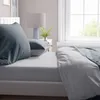 A close-up view of a bed with bedding and pillows. Produktbild-Vorschau