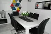 A dining room setting with a table and chairs. Podgląd zdjęcia produktu