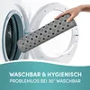 A hand is holding a gray, diamond-patterned mat and placing it into an open washing machine. Produktbild-Vorschau