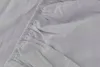 A close-up view of a light gray fitted sheet, showing the elasticized edge and fabric texture. Anteprima dell’immagine prodotto