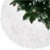 A close-up view of a white, fluffy Christmas tree skirt with a portion of a green artificial Christmas tree visible at the top. Náhled obrázku produktu