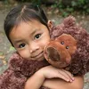 A young child hugging a stuffed bear. Anteprima dell’immagine prodotto