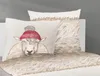 A close-up of bedding with a pillow featuring a sheep wearing a hat. Produktbild-Vorschau