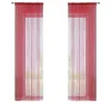 Two red string curtains hanging against a white background, with a blurred view of greenery behind them. Produktbild-Vorschau