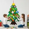 Two children are decorating a felt Christmas tree on a wall. Voir les images du produit