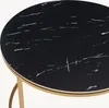 Close-up view of a round table with a black marble-patterned top and a gold-colored edge and leg. Produktbild-Vorschau