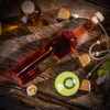 Several glass bottles and corks are arranged on a rustic wooden surface, with some decorative elements like bells and moss. Produktbild-Vorschau