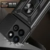 A black phone case with a magnetic ring stand and camera cover is shown at an angle, appearing to be dropped onto a surface that is cracking. Produktbild-Vorschau
