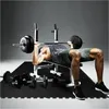 A man is performing a bench press exercise on a weight bench with a barbell. Produktbild-Vorschau