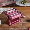 A pink Marcato Atlas 150 pasta maker is displayed on a wooden table, with a bouquet of pink tulips and a white table in the background. Náhľad obrázku produktu