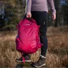 A person holding a pink backpack in an outdoor, wooded setting. Anteprima dell’immagine prodotto