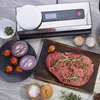 A variety of food ingredients and a vacuum sealer are arranged on a wooden table. Náhľad obrázku produktu