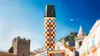 A Dolce & Gabbana branded text marker is shown in front of a scenic Italian town with buildings and a tower. Voir les images du produit