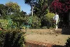 A person is using a leaf blower in a garden patio area. Produktbild-Vorschau