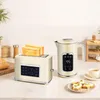 A cream-colored electric kettle and toaster set are displayed on a countertop, with toast and a cup of coffee nearby. Produktbild-Vorschau