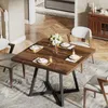 A dining table set in a dining room with chairs and a vase of flowers. Náhled obrázku produktu