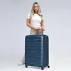 A woman standing next to a suitcase. Produktbild-Vorschau