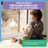 A young child sits by a window with a teddy bear, looking out at drawings of space objects on the window. Produktbild-Vorschau