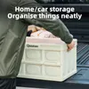 A person is placing a foldable storage box into the back of a truck. Produktbild-Vorschau