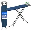 A dark blue ironing board with a built-in iron rest is shown, with a green and white iron on the rest. The ironing board is folded and standing upright on the left, and open and set up on the right. A label on the upright ironing board reads 'KADAX MADE IN Produktbild-Vorschau