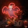 A Halloween-themed scene with a neon ghost light, skull, pumpkins, candy, a candle, and a calendar showing October 31st. Produktbild-Vorschau