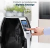 A hand is shown pressing buttons on the digital display of a black air fryer, with plants in the background. Produktbild-Vorschau