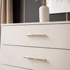 A close-up view of two drawers of a beige dresser with gold handles. Náhled obrázku produktu