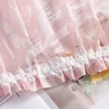 A close-up of a pink sheer curtain with a ruffled edge and text printed on it. Produktbild-Vorschau