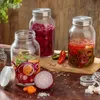 Three glass jars filled with fermented vegetables and spices, arranged on a wooden surface. Podgląd zdjęcia produktu