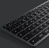 A close-up, angled view of a black keyboard with illuminated white keys against a dark gray background. Podgląd zdjęcia produktu