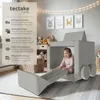 A young girl is playing inside a soft, modular play sofa shaped like a vehicle in a child's room. Náhled obrázku produktu