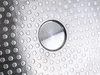 A close-up view of the textured bottom of a metal pot or pan, showing a pattern of circular indentations and a central raised circular area. Podgląd zdjęcia produktu
