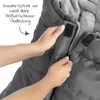 Hands are shown closing a zipper on a gray stroller footmuff, with text indicating additional wind protection. Náhled obrázku produktu