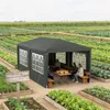 A dark gray garden pavilion set up in a vegetable garden with people sitting inside. Voir les images du produit