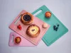 Three cutting boards of different sizes and colors are arranged diagonally on a light gray background. Various baked goods, a strawberry, an egg, and blueberries are placed on the cutting boards. Produktbild-Vorschau