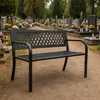 A black metal park bench sits in a cemetery with gravestones and flowers in the background. Anteprima dell’immagine prodotto