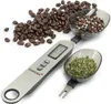 A digital spoon scale with coffee beans, peppercorns, and dried herbs. Voir les images du produit