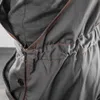 A close-up view of a gray garment with orange stitching. Produktbild-Vorschau