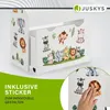 A white wooden bookshelf with a toy drawer, decorated with cartoon animal stickers, is shown. A hand is applying a sticker to a separate sheet of stickers in the foreground. Podgląd zdjęcia produktu