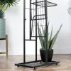 A black metal plant stand with multiple shelves, holding a potted aloe vera plant. Náhled obrázku produktu