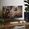 A gaming monitor displaying a jungle scene, with a keyboard and game controller on a wooden desk. Produktbild-Vorschau