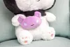 A close-up of a white teddy bear with a black scarf and a small purple plush toy attached to its chest. Voir les images du produit