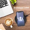 A desk scene with a laptop, coffee, and a phone charging wirelessly. Produktbild-Vorschau